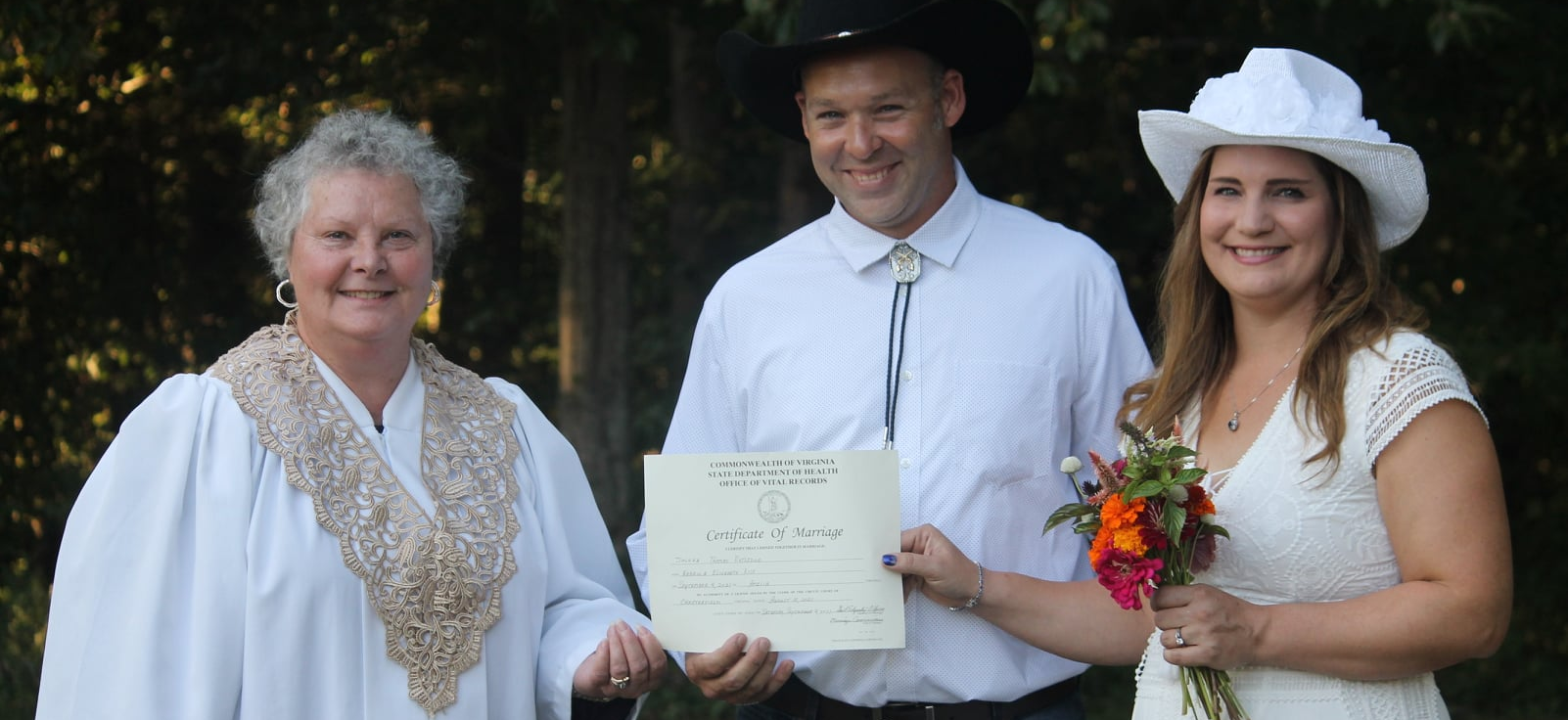 couple holding up marriage license after elopement in Virginia